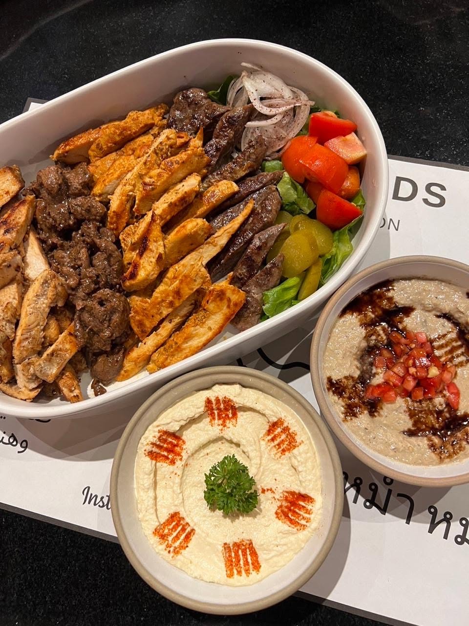 Hummus Heads shawarma wraps served with pickles, tomato, onion and lemon