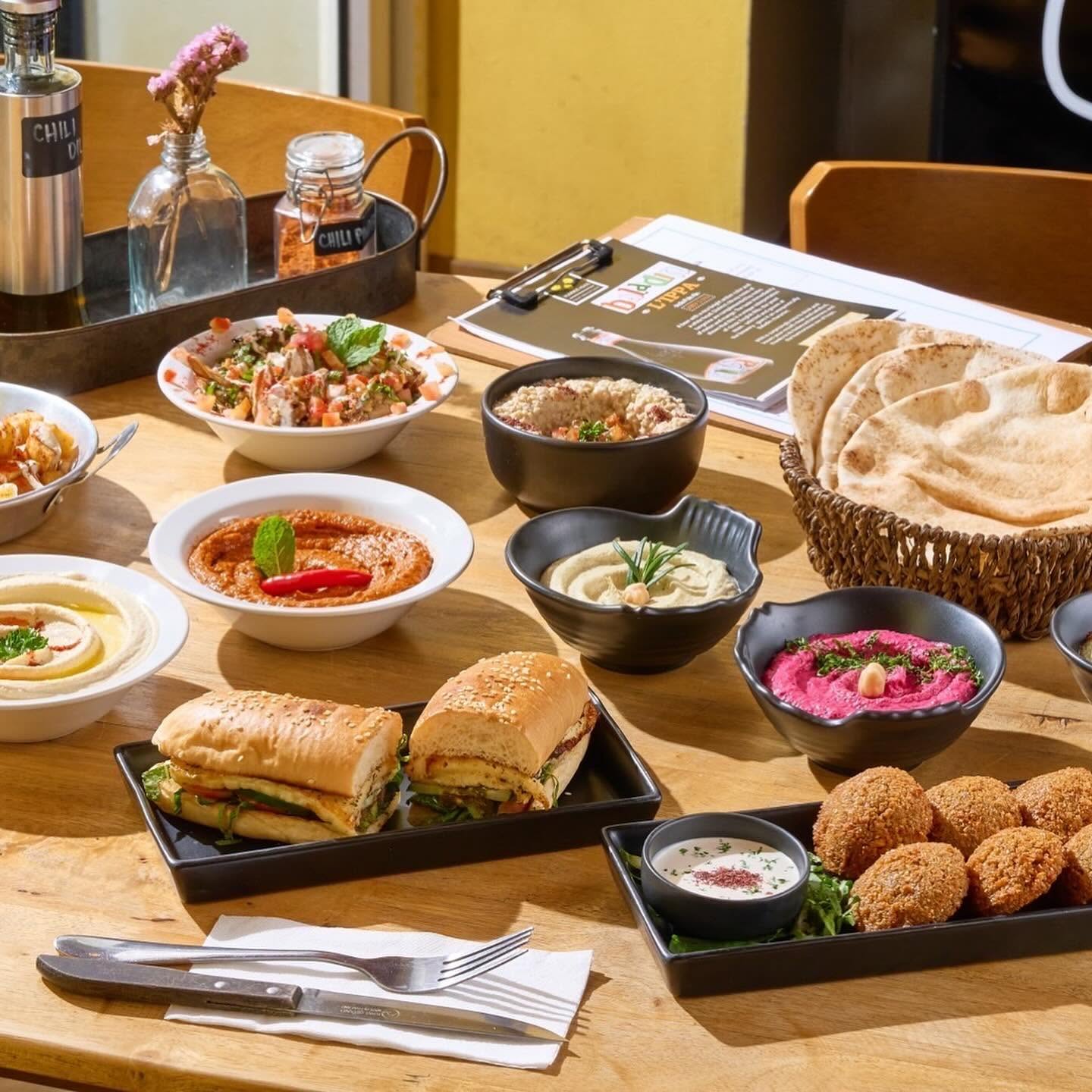 A hearty platter of chicken wings, falafel, fries and pickled vegetables at Hummus Heads